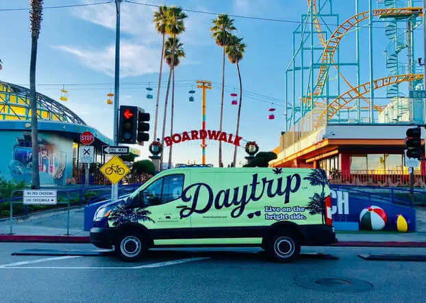 the green daytrip team sprinter van parked in front of the santa monica pier
